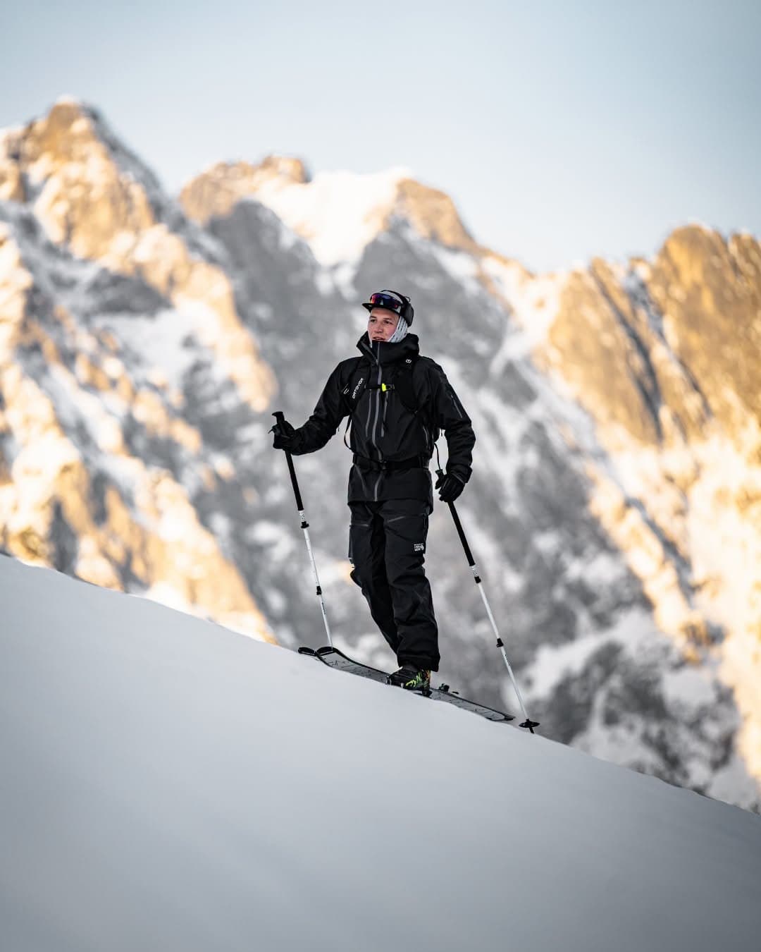 Ski tourer climbing through alpine snow on Kästle skis